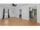 Living room with wood grain floors, a ceiling fan, and a doorway leading to the kitchen at 140 Flag Patch Rd., Loris, SC 29569