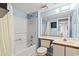 Bathroom with white fixtures, blue walls, a shower-tub combo, and a large mirror reflecting the space at 1425 S Ocean Blvd. # 8-B, North Myrtle Beach, SC 29582