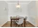 Dining area featuring a contemporary light fixture, table set, and hardwood floors at 178 Clubhouse Dr. # 3, Sunset Beach, NC 28468