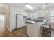 Well-lit kitchen featuring white cabinets, bar seating, and modern appliances at 178 Clubhouse Dr. # 3, Sunset Beach, NC 28468