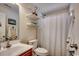 Bright bathroom featuring a shower with tub, white tile, and cherry cabinet at 179 Heath Dr., Longs, SC 29568