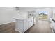 Kitchen island with white cabinets, stainless steel appliances and backyard view through sliding glass doors at 2024 Copper Creek Loop, Longs, SC 29568