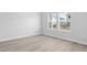 Serene bedroom with light gray wood-look flooring and white walls at 2044 Copper Creek Loop, Longs, SC 29568