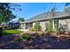 A beautifully landscaped backyard with a screened porch and lush greenery at 221 Portrush Loop, Pawleys Island, SC 29585