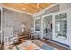 Cozy screened porch features a wood ceiling and rocking chairs for relaxing at 221 Portrush Loop, Pawleys Island, SC 29585