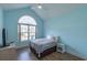 A cozy bedroom is painted in calming light blue hues with a large arched window and ceiling fan at 227 Old Hickory Dr., Conway, SC 29526