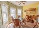 Sunlit dining area features a glass table, wicker chairs, tropical wallpaper, and built-in shelving at 227 Old Hickory Dr., Conway, SC 29526