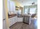 Cozy kitchen features white cabinets, stainless steel appliances, and a dining area with tropical wallpaper at 227 Old Hickory Dr., Conway, SC 29526
