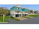 Exterior view of two-story homes featuring coastal colors, elevated decks, and ground-level garages at 2304 Seaseeker Ln., Myrtle Beach, SC 29579