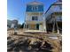 Spacious carport of an elevated beach home with sturdy white support columns and painted blue walls at 2304 Seaseeker Ln., Myrtle Beach, SC 29579