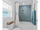 Clean bathroom with a white tub, blue tiled wall, and window for natural light at 2306 Seaseeker Ln., Myrtle Beach, SC 29577