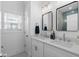Bright bathroom featuring double sink vanity, framed mirrors, and a window providing natural light at 2306 Seaseeker Ln., Myrtle Beach, SC 29577