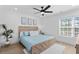 Well-lit bedroom showcasing light blue bedding, a wood-framed bed, and large windows at 2306 Seaseeker Ln., Myrtle Beach, SC 29577