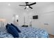 This is a bright bedroom with wood flooring, TV, ensuite bathroom and shell themed bedspread at 2306 Seaseeker Ln., Myrtle Beach, SC 29577