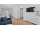 Bright room with wood floors, and a comfy blue sofa in front of a console and large screen TV at 2306 Seaseeker Ln., Myrtle Beach, SC 29577