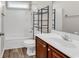 This bathroom features a tub-shower combo, wood-look flooring, and a modern vanity with ample counter space at 2454 N Windmill Way, Myrtle Beach, SC 29579