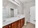 Bright bathroom featuring a double sink vanity, large mirror with vanity lighting, and white painted doors at 2454 N Windmill Way, Myrtle Beach, SC 29579