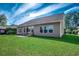 Spacious backyard showcasing a well-maintained lawn and the rear exterior of the house with multiple windows at 2749 Sanctuary Blvd., Conway, SC 29526