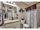 Well-lit bathroom features a granite vanity, decorative mirror and shower with curtain at 2749 Sanctuary Blvd., Conway, SC 29526