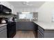 Well-lit kitchen with granite countertops, white upper cabinets, and black appliances at 311 Cumberland Terrace Dr. # 7-E, Myrtle Beach, SC 29572