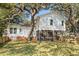 Backyard with mature trees, covered porch, and white siding on the home at 315 Oak Dr. N, Surfside Beach, SC 29575