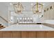 Bright, open kitchen featuring an oversized marble island, custom cabinetry, and modern light fixtures at 373 St. Julian Ln., Myrtle Beach, SC 29579