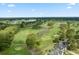 Scenic aerial view of the golf course community featuring lush green fairways, water hazards, and surrounding houses at 4746 Harvest Dr., Myrtle Beach, SC 29579