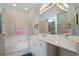 Bright bathroom with a soaking tub, vanity, and large mirror at 4746 Harvest Dr., Myrtle Beach, SC 29579