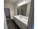 Well-lit bathroom with a quartz countertop vanity, spacious mirror, and wood-look flooring at 531 Tillage Ct., Conway, SC 29526