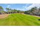 Scenic view of lush green golf course with mature trees in the background at 5508 Leatherleaf Dr., North Myrtle Beach, SC 29582