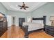 A large, relaxing main bedroom with a ceiling fan, wood floors and a large window at 5508 Leatherleaf Dr., North Myrtle Beach, SC 29582