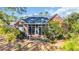 Rear exterior view of a brick home featuring a screened porch and patio area at 5508 Leatherleaf Dr., North Myrtle Beach, SC 29582