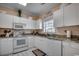 Well-lit kitchen features white cabinetry, granite counters, and stainless-steel appliances at 5750 Oyster Catcher Dr. # 522, North Myrtle Beach, SC 29582