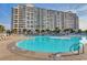 Expansive pool area with comfortable lounge chairs and umbrellas located near the condo buildings at 5750 Oyster Catcher Dr. # 522, North Myrtle Beach, SC 29582