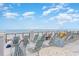 Relax on the rooftop deck with ample lounge chairs and stunning ocean views under a bright, cloudy sky at 5750 Oyster Catcher Dr. # 522, North Myrtle Beach, SC 29582