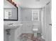 Well-lit bathroom with pedestal sink, toilet, wainscoting, and tiled floor at 609 23Rd Ave. N, North Myrtle Beach, SC 29582