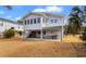 Rear exterior of elevated home features ground-level patio, swing and staircase to the upper deck at 609 23Rd Ave. N, North Myrtle Beach, SC 29582