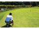 Personal prepares to putt on a well-manicured golf green adjacent to a pond at 6804 N Ocean Blvd. # 533, Myrtle Beach, SC 29572