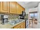 Functional kitchen featuring wooden cabinets, tiled backsplash, and essential appliances, blending style with practicality at 6804 N Ocean Blvd. # 533, Myrtle Beach, SC 29572