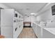 Well-lit laundry room featuring multiple washers, dryers, folding table, and light wood flooring at 6804 N Ocean Blvd. # 533, Myrtle Beach, SC 29572