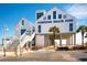 Surfside Beach Pier entrance with white buildings, blue accents, and clear blue sky at 694 Harrison Mill St., Myrtle Beach, SC 29579