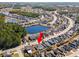 Wide aerial view of a neighborhood with the subject property marked by a red arrow near a pond at 726 Carolina Farms Blvd., Myrtle Beach, SC 29579