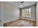 Bright bedroom featuring wood flooring, a ceiling fan, and large windows with plantation shutters at 726 Carolina Farms Blvd., Myrtle Beach, SC 29579