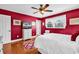 Bright bedroom featuring red walls, hardwood floors, and a comfortable bed at 7609 Brentwood Dr., Myrtle Beach, SC 29572