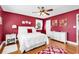 Bright bedroom with red walls, hardwood floors, ceiling fan, and white furniture at 7609 Brentwood Dr., Myrtle Beach, SC 29572