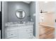 Bathroom features a gray vanity with marble top and a round mirror at 8533 Cedar Trace Dr., Myrtle Beach, SC 29588