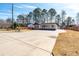 Expansive driveway leading to a charming home with a welcoming porch, surrounded by a well-maintained yard and mature trees at 8533 Cedar Trace Dr., Myrtle Beach, SC 29588