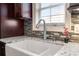 Close up of farmhouse sink, granite countertop, mosaic tile backsplash and updated faucet at 8533 Cedar Trace Dr., Myrtle Beach, SC 29588