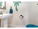 Pedestal sink and teal palm tree decoration adds a pop of color in the powder room at 9000 Mabel Ct., Longs, SC 29568