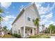 View of a two-story home showcasing landscaping and a charming porch with chairs at 9000 Mabel Ct., Longs, SC 29568